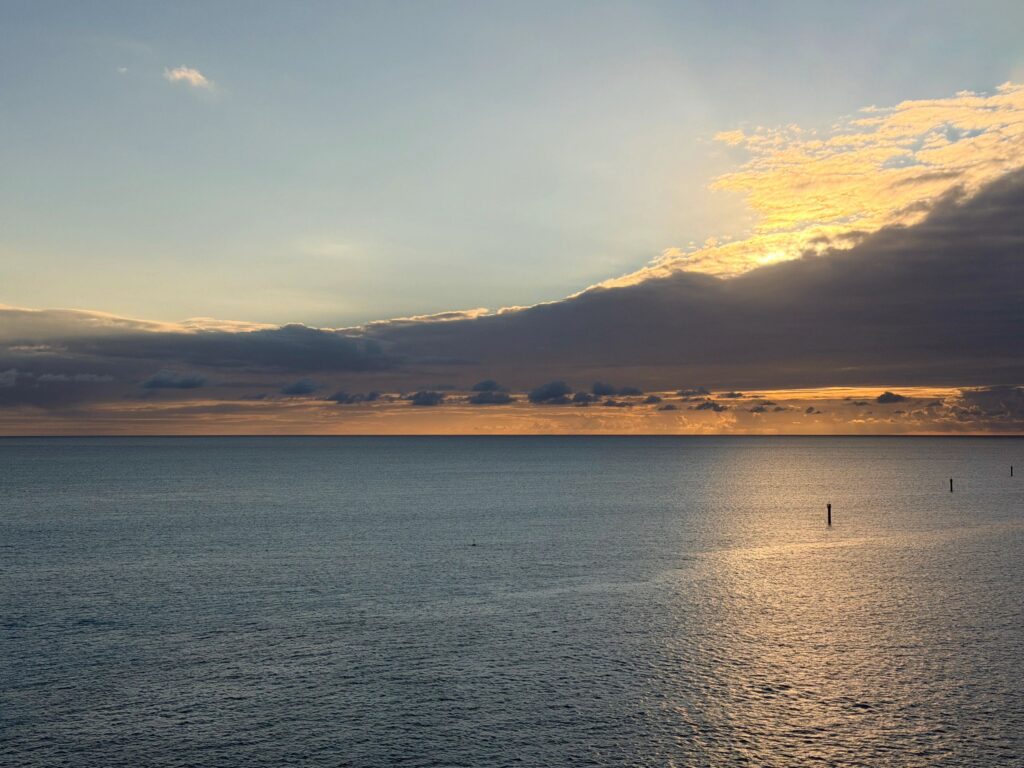 Golden sunset light reflecting on calm ocean water