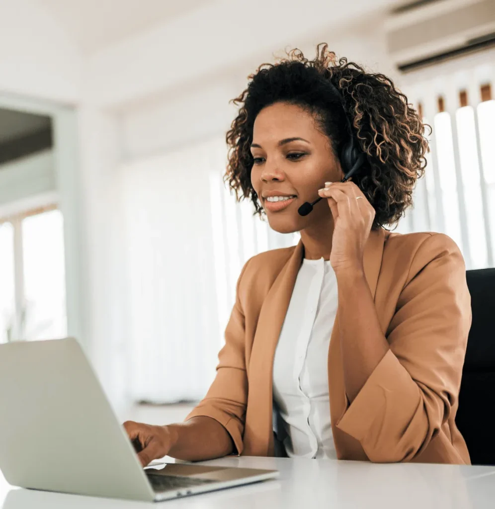 Professional customer-service representative wearing a headset while working on a laptop